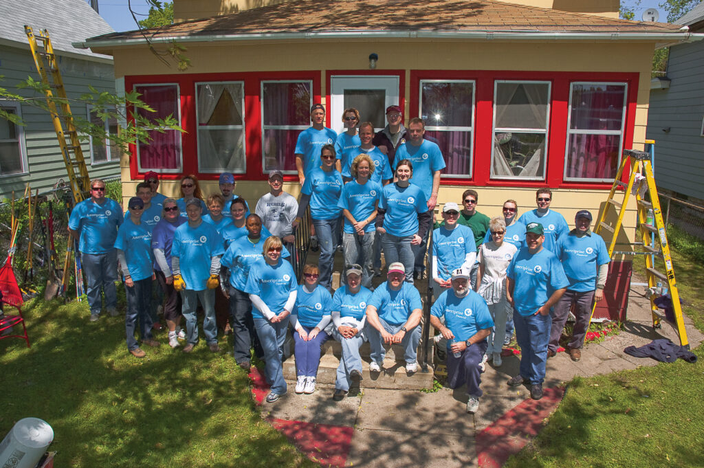 Volunteers posing in front of a home that was worked on