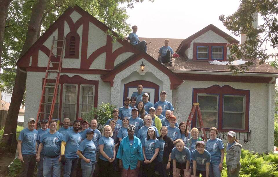 Volunteers posing in front of the home they are enhancing
