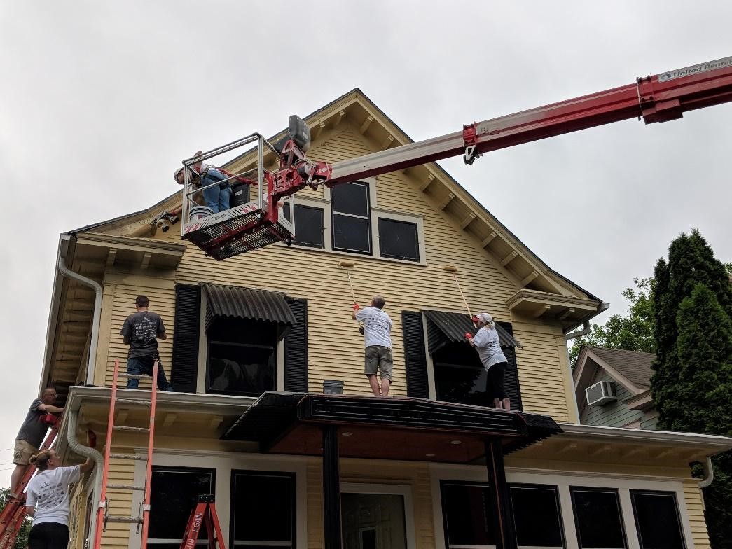 Home exterior work being done on a yellow house