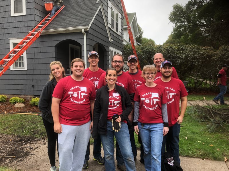 A team smiles while waiting to improve a local home in need