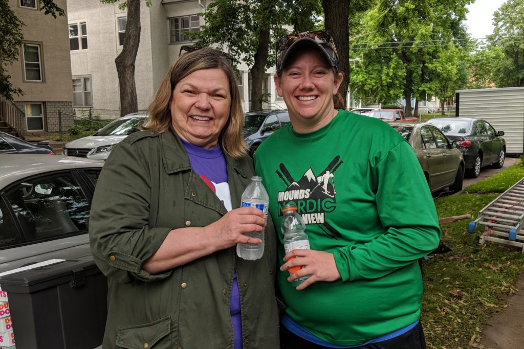 A couple of volunteers pose while holding their water bottles