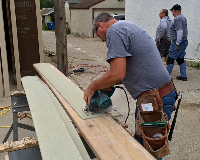 Planks of wood being sawn outside