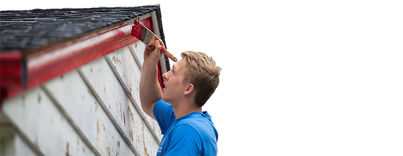 A volunteer painting the trim of a home